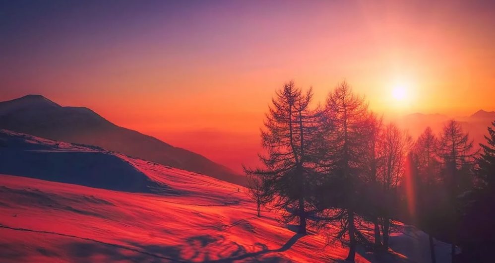 Sunset over a snowy mountain.