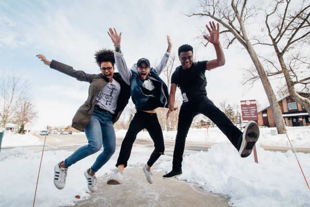 Group of friends jumping in celebration in the snow