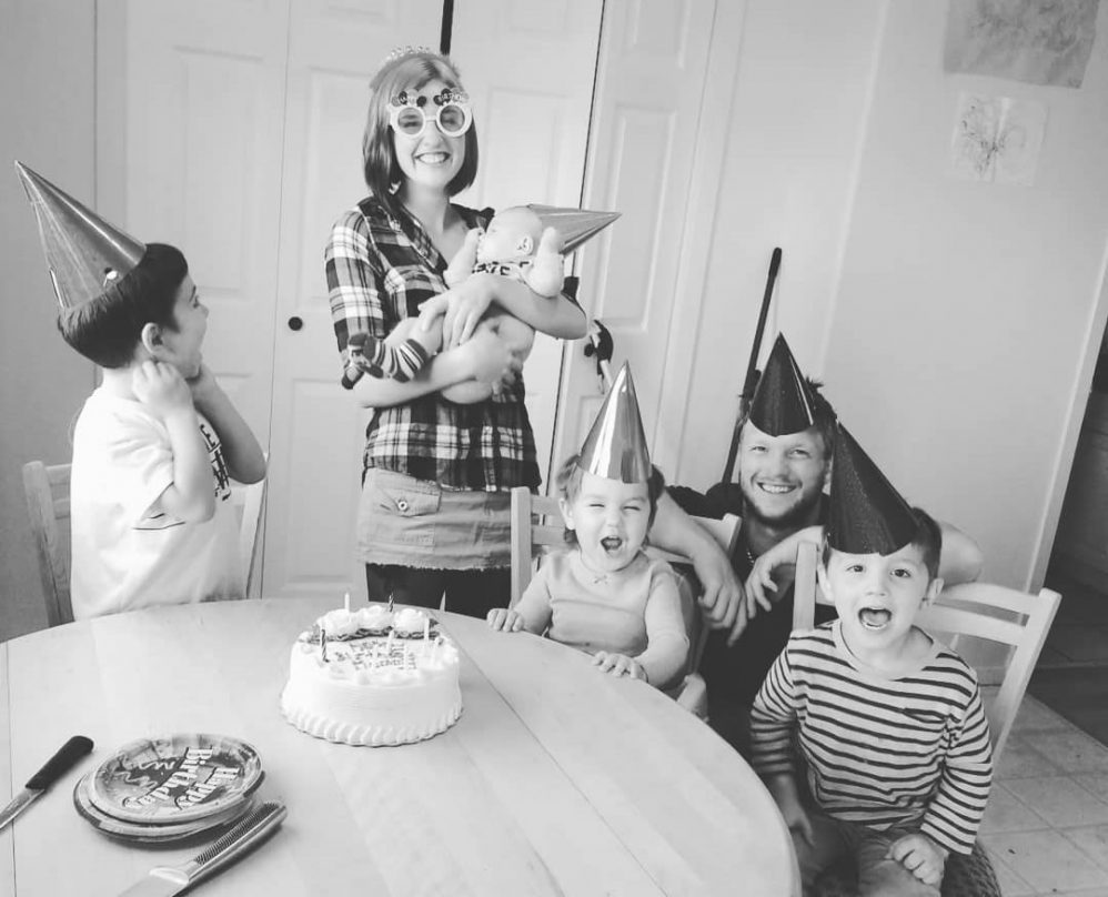 Family celebrates a birthday. Mom and dad with four kids. Black and white.