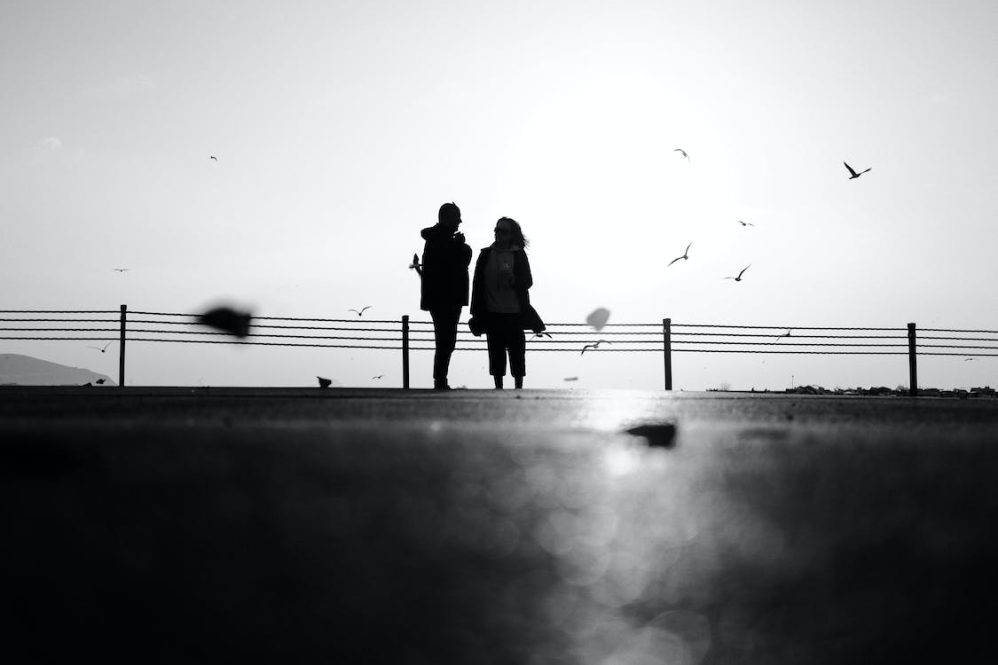 A silhouette of a couple walking on the beach